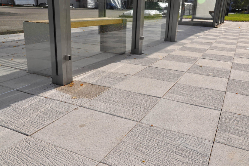 Strukturerad antracitfärgad Ravel-platta från S:T Eriks som kombinerar elegans och funktionalitet, perfekt för offentliga miljöer som gångbanor och torg. Stengrossen säljer produkten.