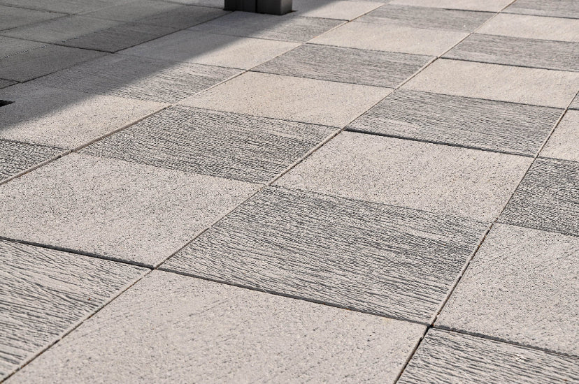 Offentlig plats med Ravel-plattor i en mix av vitt och antracit från S:T Eriks, ger ett levande och elegant mönster. Stengrossen säljer produkten.