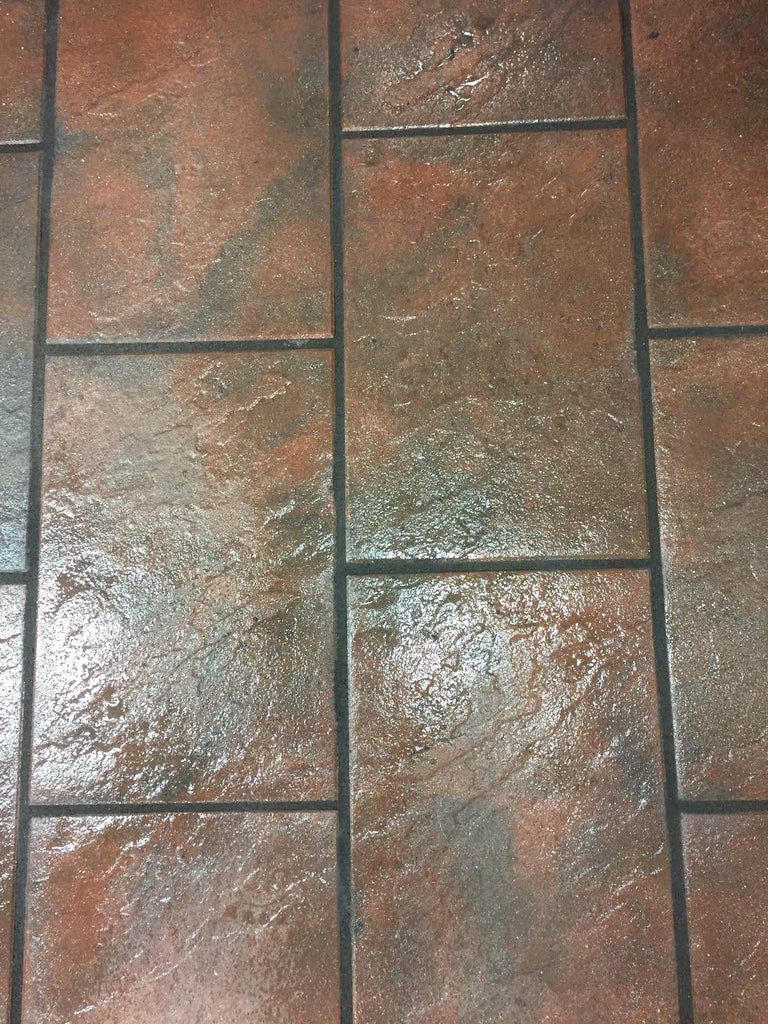 Närbild av Gerlo-platta från S:T Eriks i röd-svart färg med finblästrad yta och skyddande impregnering. Perfekt för estetiska vistelseytor. Denna betongplattan har storleken 400x600x45 mm. Stengrossen säljer produkten.