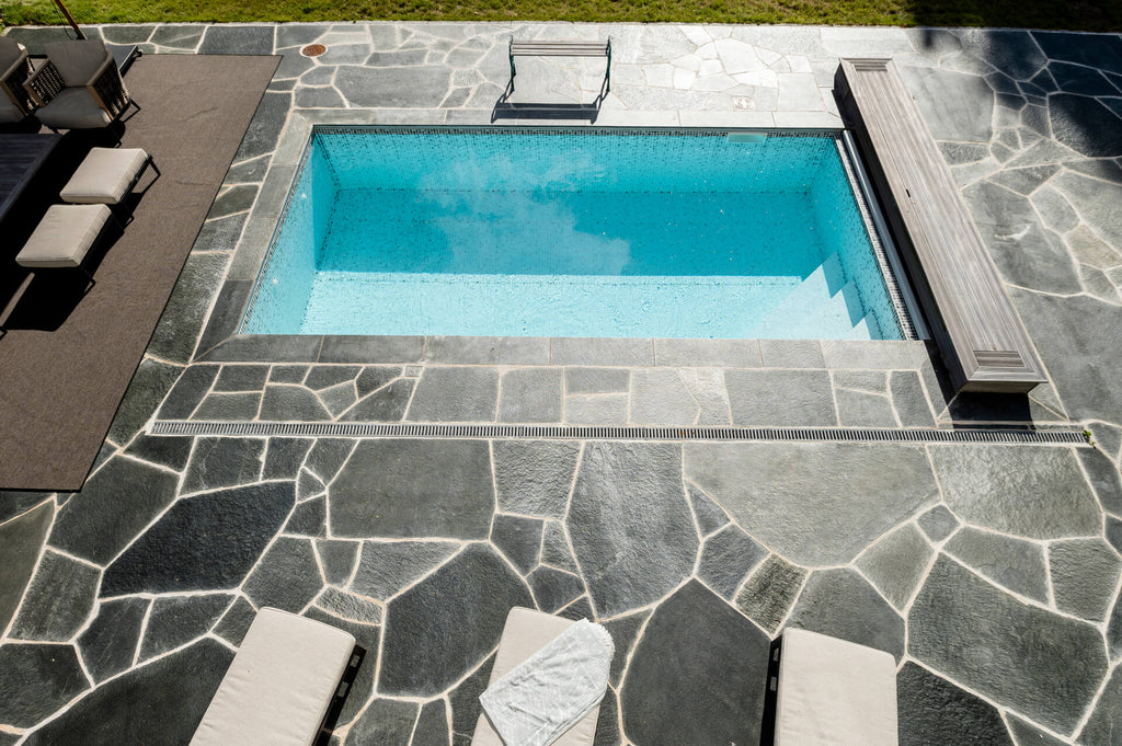 Stilfull utomhusmiljö med Offerdalsskiffer runt pool i villaområde, Stockholm. Stengrossen säljer produkten