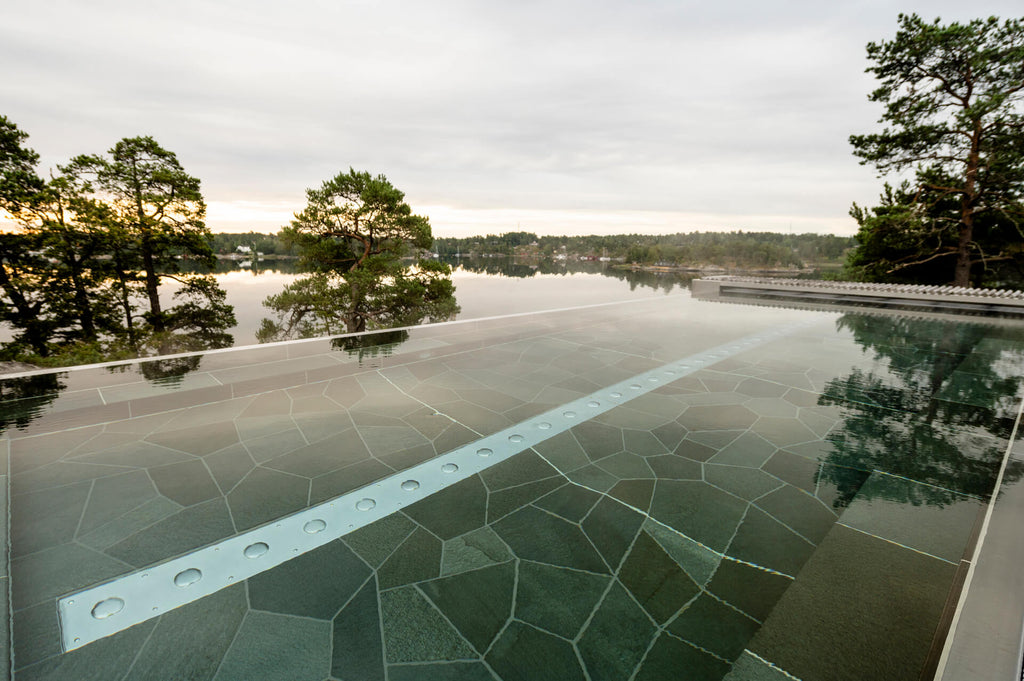 Offerdalsskiffer lagd runt poolområde på Djurönäset, med naturliga skiftningar i grått – Stengrossen säljer produktenOfferdalsskiffer lagd runt poolområde på Djurönäset, med naturliga skiftningar i grått – Stengrossen säljer produkten
