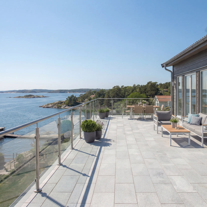 Uteplats vid havet med grå granitplattor 60x30x3 cm i solsken och möbler för avkoppling, Stengrossen säljer produkten.