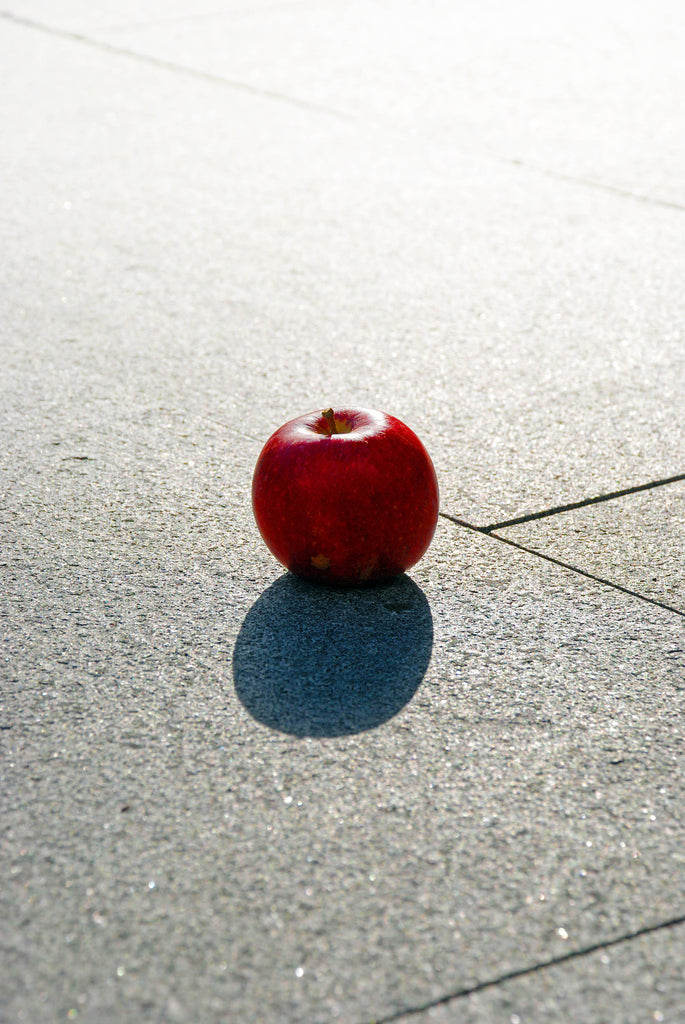 Grå granitplattor. Ovanpå plattorna ligger det ett rött äpple. Säljs av Stengrossen.se