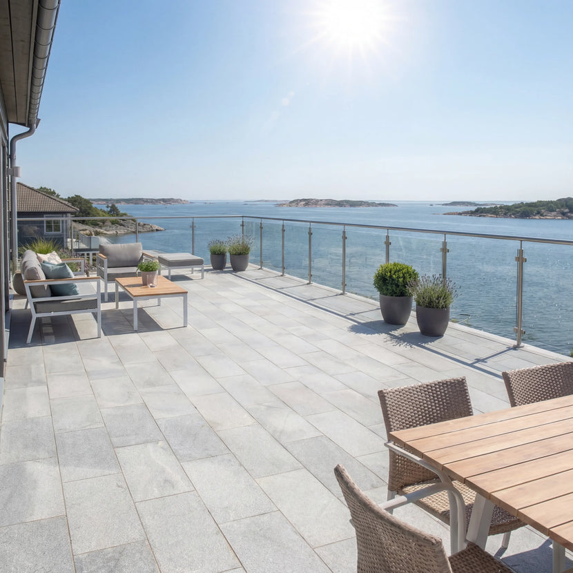 Grå granitplatta 60x30x3 cm lagd på uteplats vid havet med solbelyst miljö och stilrena utemöbler, Stengrossen säljer produkten