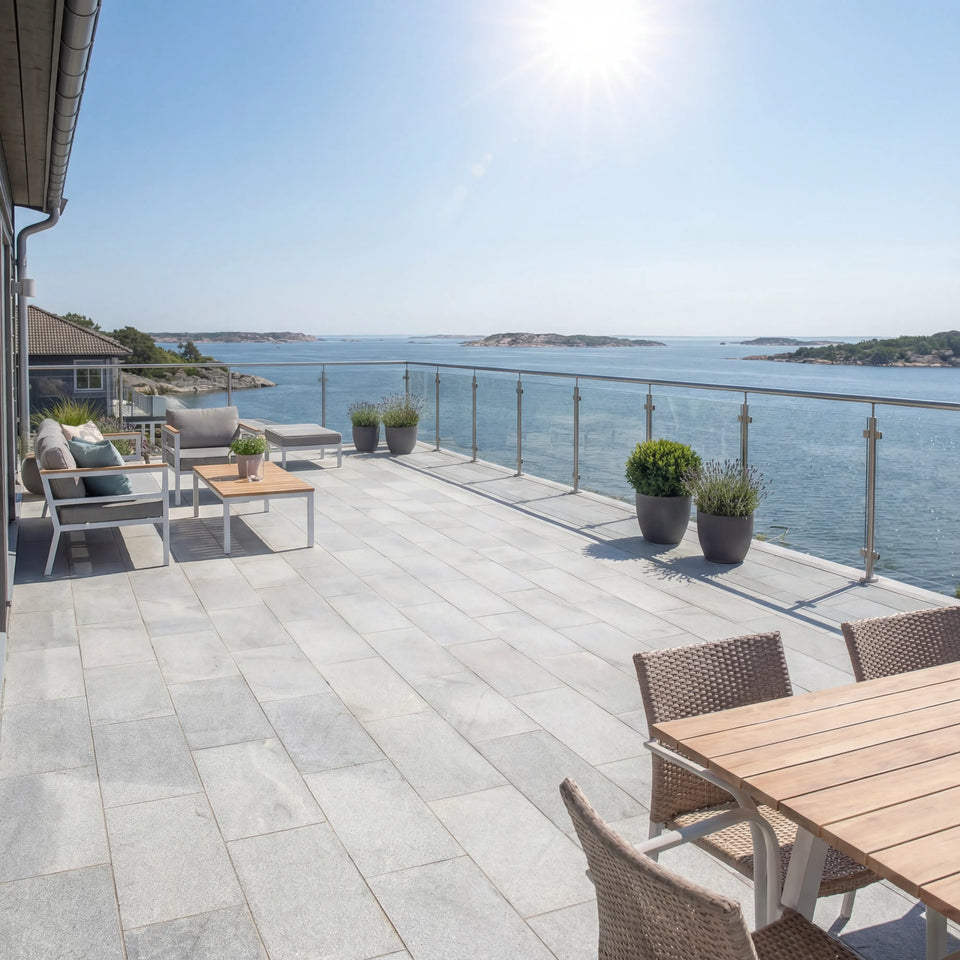 Grå granitplatta 60x30x3 cm lagd på uteplats vid havet med solbelyst miljö och stilrena utemöbler, Stengrossen säljer produkten