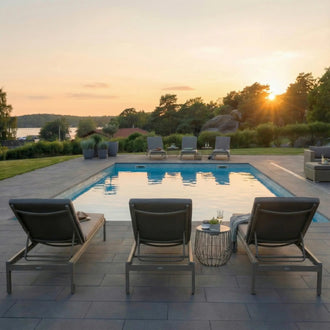 Granitplatta i grafit 60x30x3 cm lagd runt poolområde med utemöbler och blommor, Stengrossen säljer produkten.