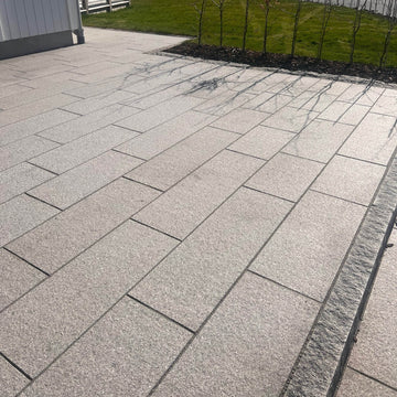 Svensktillverkad granithäll i Grå Bohus med flammad yta och sågade sidor, Stengrossen säljer produkten.