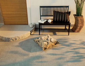 Plattor av granit. Ligger framför ett hs med en trädörr. Framför dörren ligger det ett entréplan i granit. Ovanpå plattorna står det en kruka samt en soffa i svart trä. Säljs av Stengrossen.se