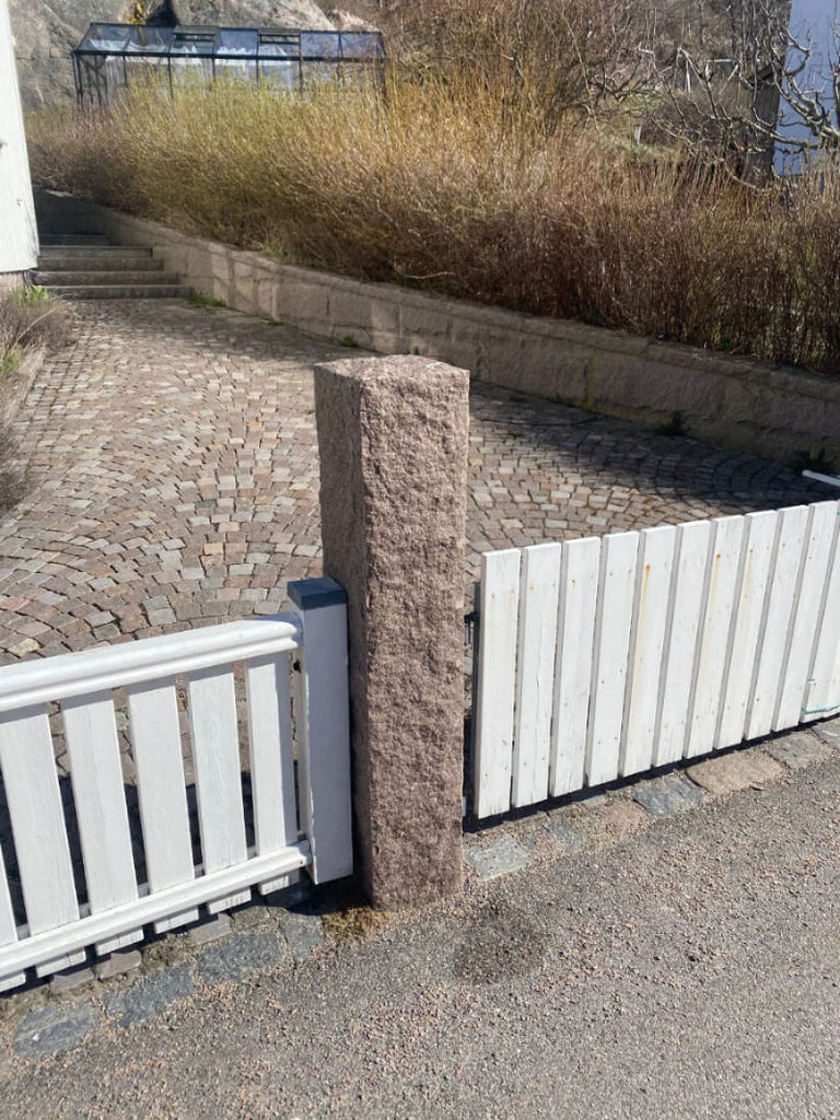 Svensktillverkad röd granitstolpe med naturlig råkilad yta. Stengrossen säljer produkten.