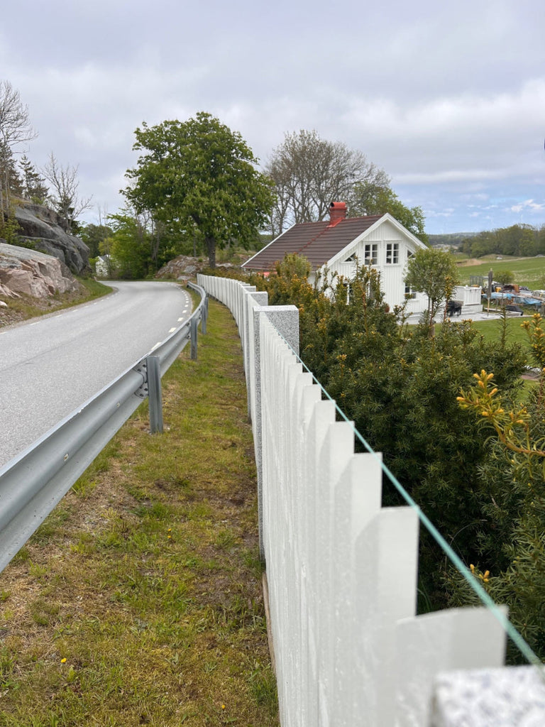 Stilrena flammade granitstolpar som skapar en elegant trädgårdsmiljö. Stengrossen säljer produkten.