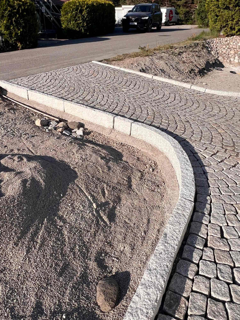 Smågatsten, även kallad för gatsten och knott. Inramas av kantsten av typen GV4. Kantstenen är på bägge sidor av en infart. Säljs av Stengrossen.se