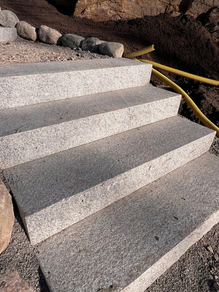 Blocksteg i granit för trädgårdstrappor – Slitstarkt granitsteg med flammad ovansida och stabil konstruktion. Stengrossen säljer produkten.