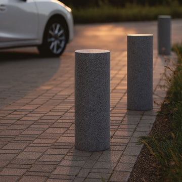 Pollare i gr granit. Pollaren är formad som en cylinder och har måtten 120x30 cm. Toppen av pollaren är polerad och utsidan av cylindern är flammad. Stengrossen säljer produkten.