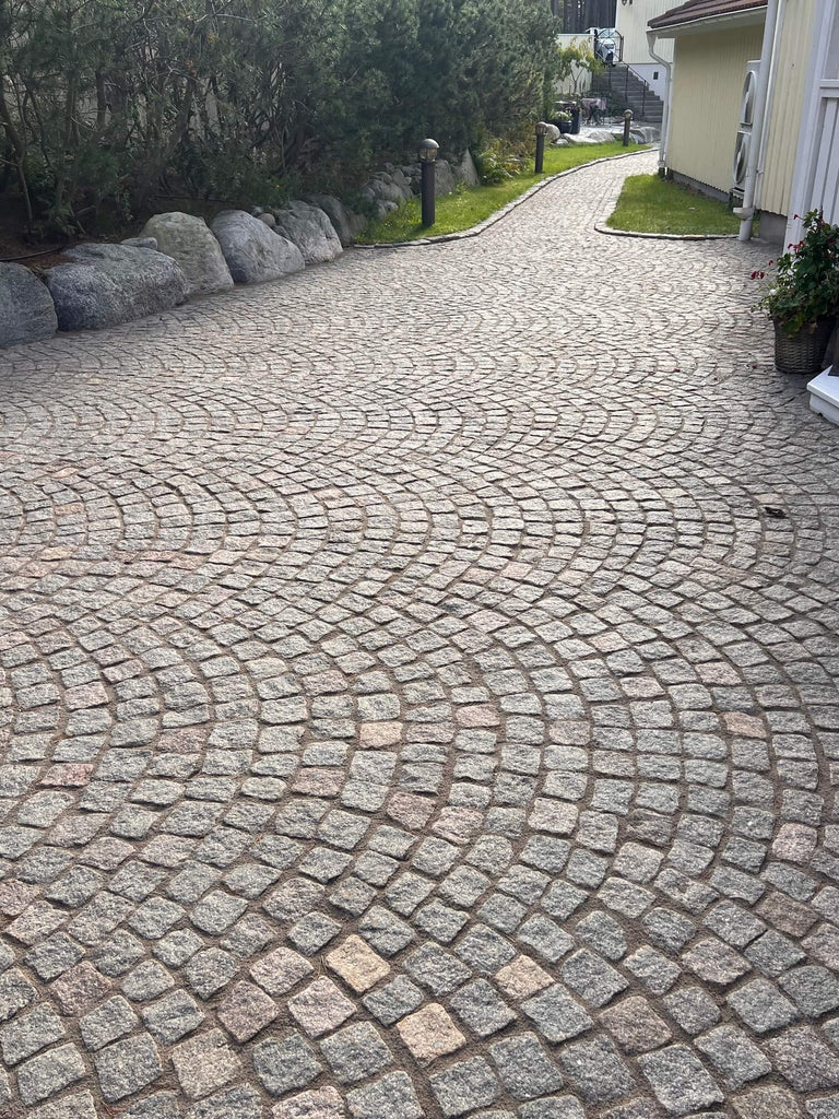 Gatsten (smågatsten) som är lagd i bågmönster. Stenen är tillverkad i Sverige och färgen kallas Grå Bohus. Storleken på stenen är 8/11 cm. Som fogmassa kring denna gatsten ligger det Pavifix 1K Extra med färgen grå. Säljs av Stengrossen.se