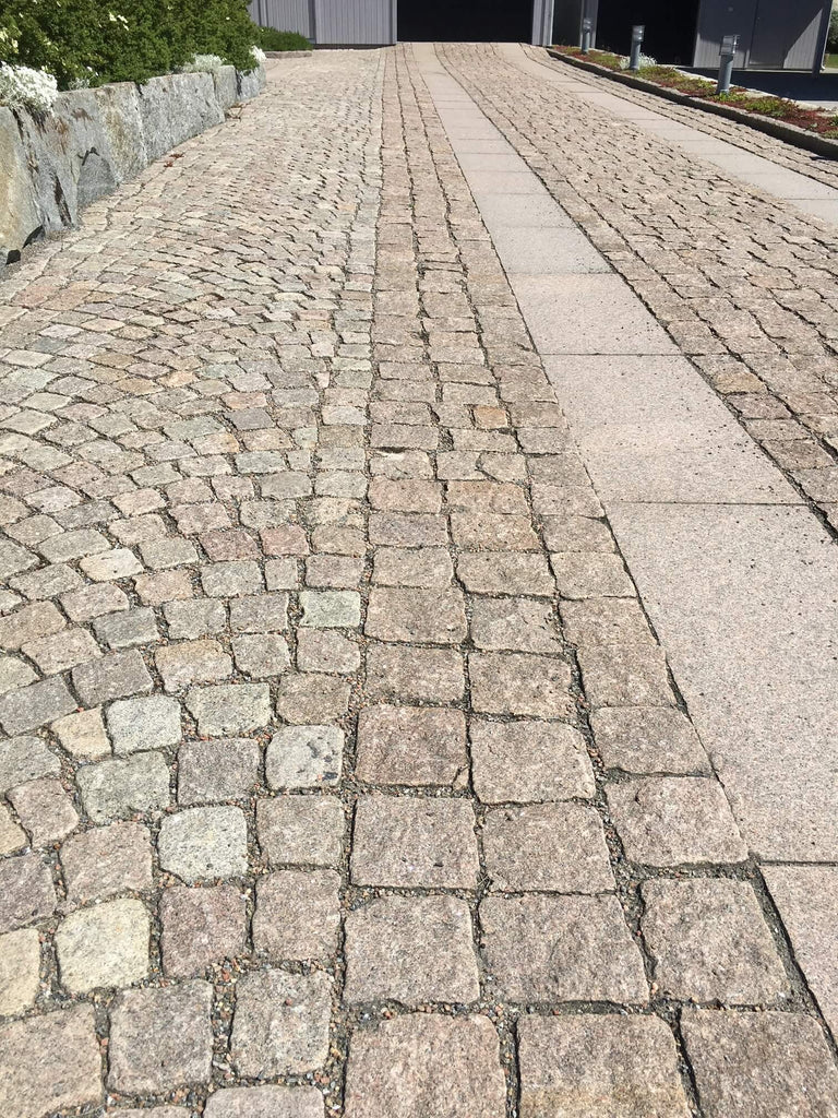 Smågatsten, även kallad gatsten och knott, som är lagd på en garageuppfart. Gatstenen är både lagd i bågmönster och raksättning. Två rader med granithäller löper längs med gatstenen. Säljs av Stengrossen.se
