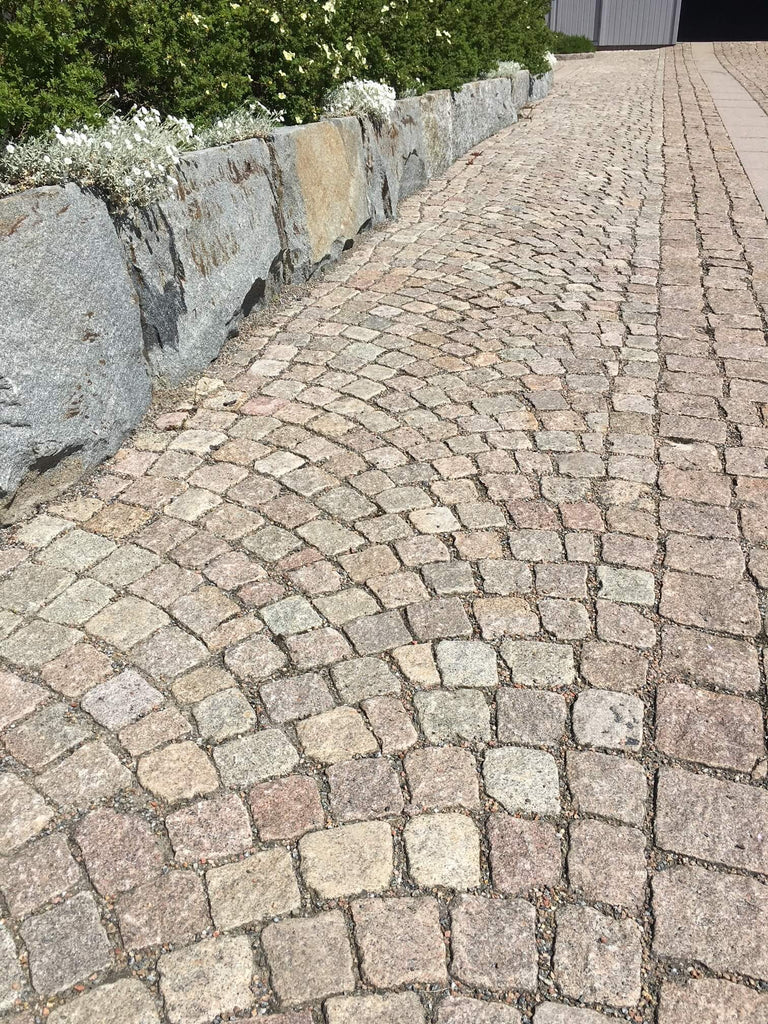 Smågatsten, tillverkad i Sverige av sorten Röd Bohus. Lagd i bågmönster och raksättning. Till vänster i bild är det en mur av blandade stensorter. Säljs av Stengrossen.se