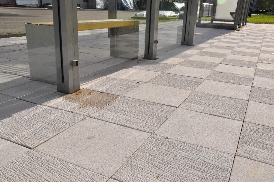 Vit Ravel-trädgårdsplatta med stilren ytstruktur, idealisk för torg, gångstråk och andra offentliga platser. Storleken är 400x400x60 mm. Stengrossen säljer produkten.