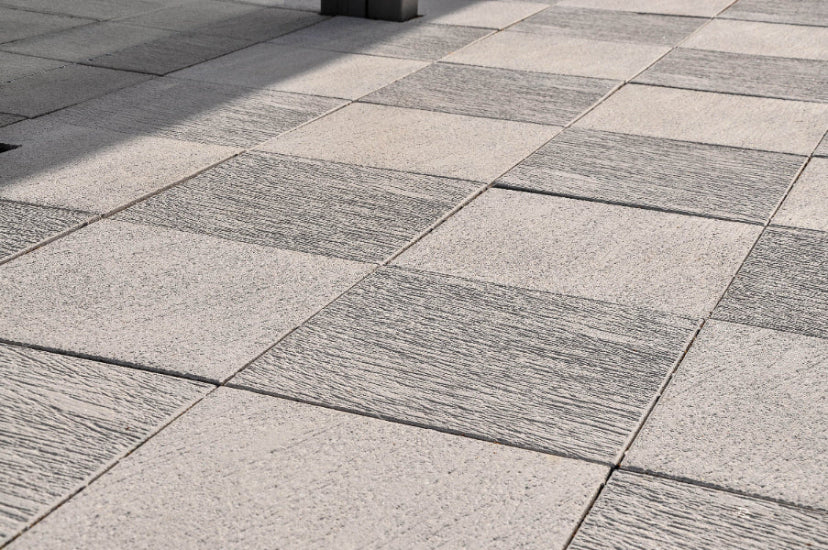 Närbild av antracitfärgad Ravel-platta från S:T Eriks med blästrad och lättborstad yta, skapar ett elegant uttryck i offentliga utemiljöer. Stengrossen säljer produkten.