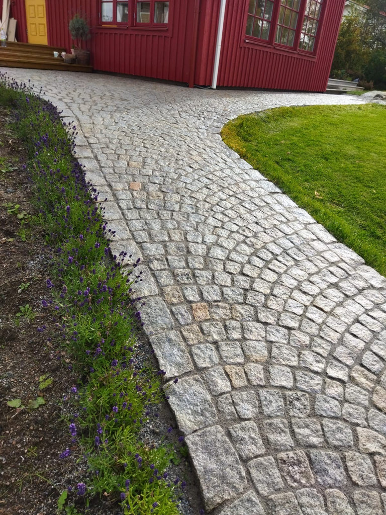 Svensk smågatsten och storgatsten. Regnblöt sten. Fogad med hårdfog som dränerar vatten. Fogen tillverkad av PCI. Fogen har färgen grå och heter Pavifix 1K Extra. Säljs av Stengrossen.se