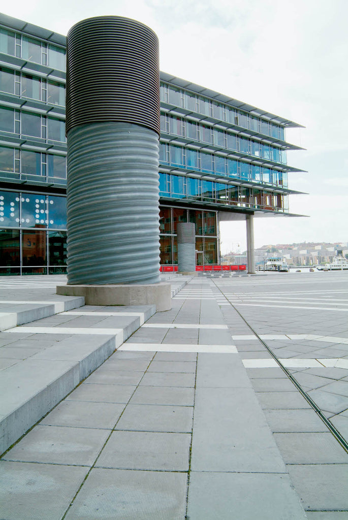 Grå Superplattan använd på ett modernt torg, där den täta betongen och exakta formen ger en harmonisk och slitstark beläggning. Stengrossen säljer produkten. Tillverkad av S:T Eriks