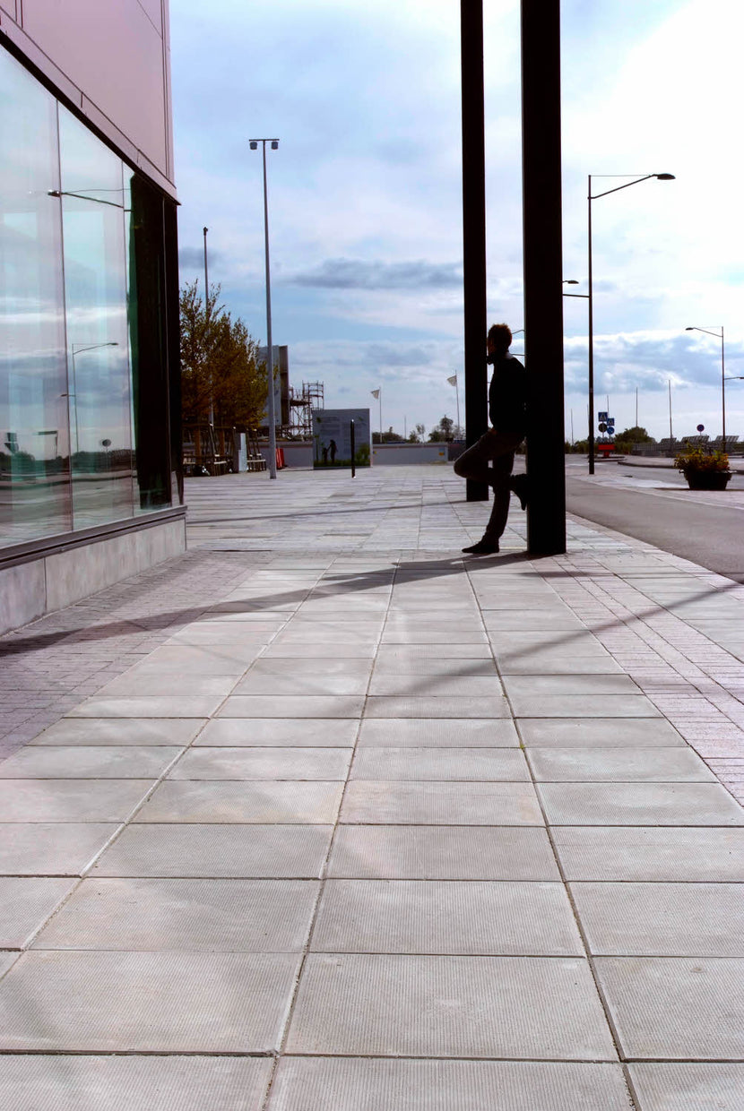 Torgyta belagd med Superplattan grå, som framhäver rena linjer och en tidlös design i offentlig miljö. Stengrossen säljer produkten och den tillverkas av S:T Eriks.