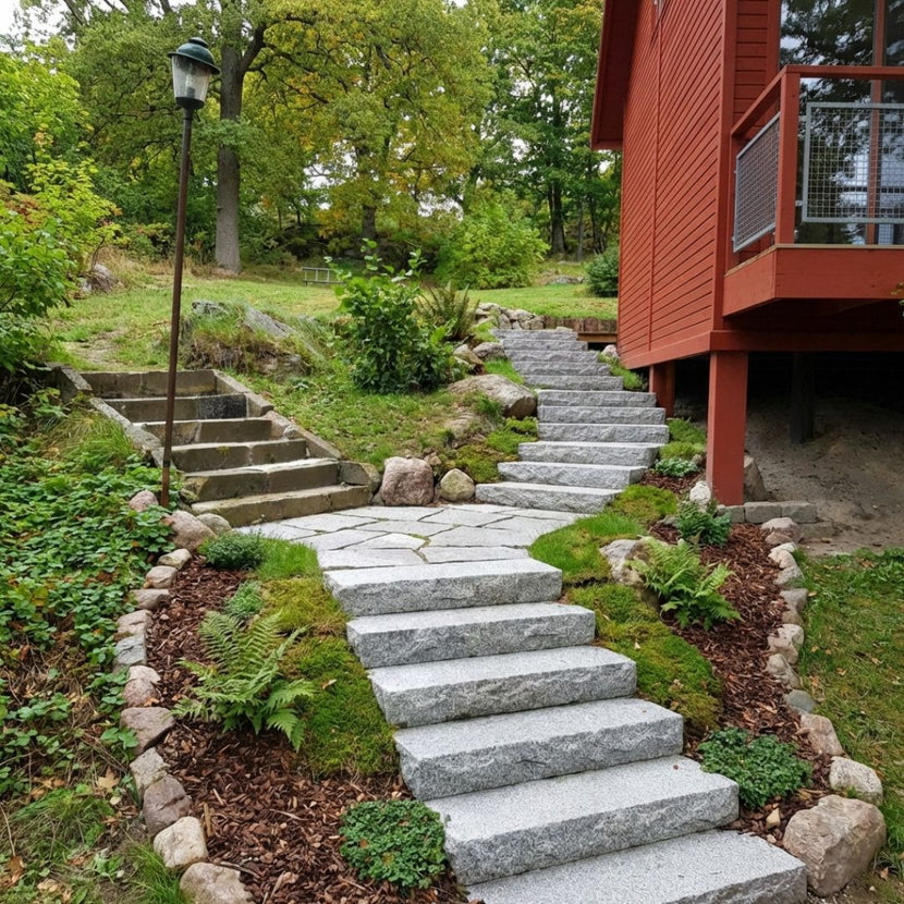 Grå granittrappsteg från Stengrossen i en slänt som formar en svängd trappa.