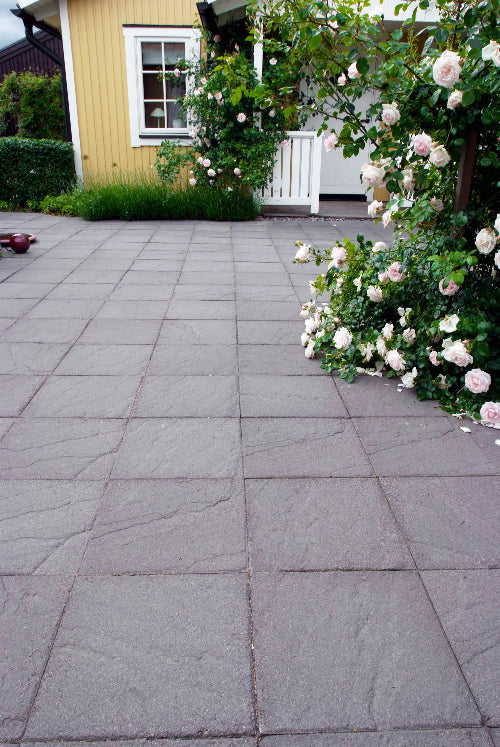 Antracitfärgad Structura-platta kallad Lava från S:T Eriks med skifferinspirerad ytstruktur, idealisk för parker, gångstråk och lätt trafikerade uppfarter. Stengrossen säljer produkten.