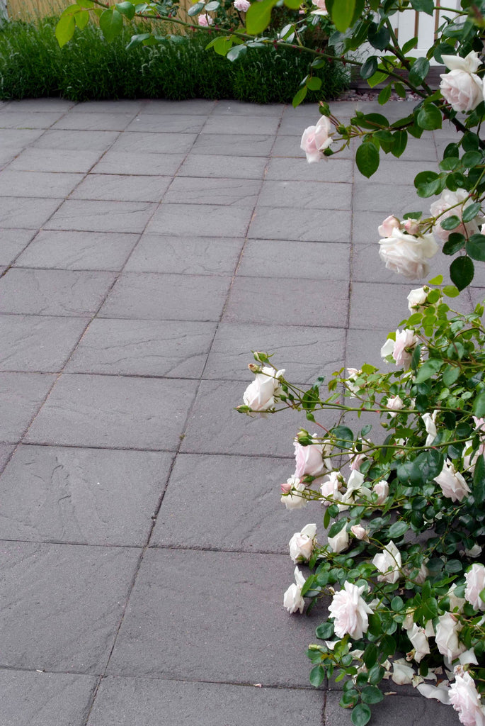 Structura-plattor i Lava från S:T Eriks, stilrent lagda i en trädgårdsmiljö för en tidlös och sofistikerad stenläggning. Stengrossen säljer produkten.