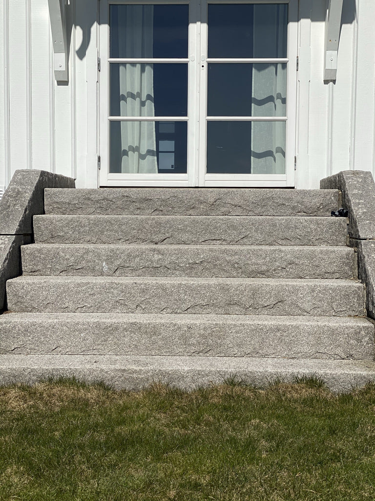 Trappa med sex granitsteg och robusta vangstycken som ger en stabil och snygg inramning. Stengrossen säljer produkten.