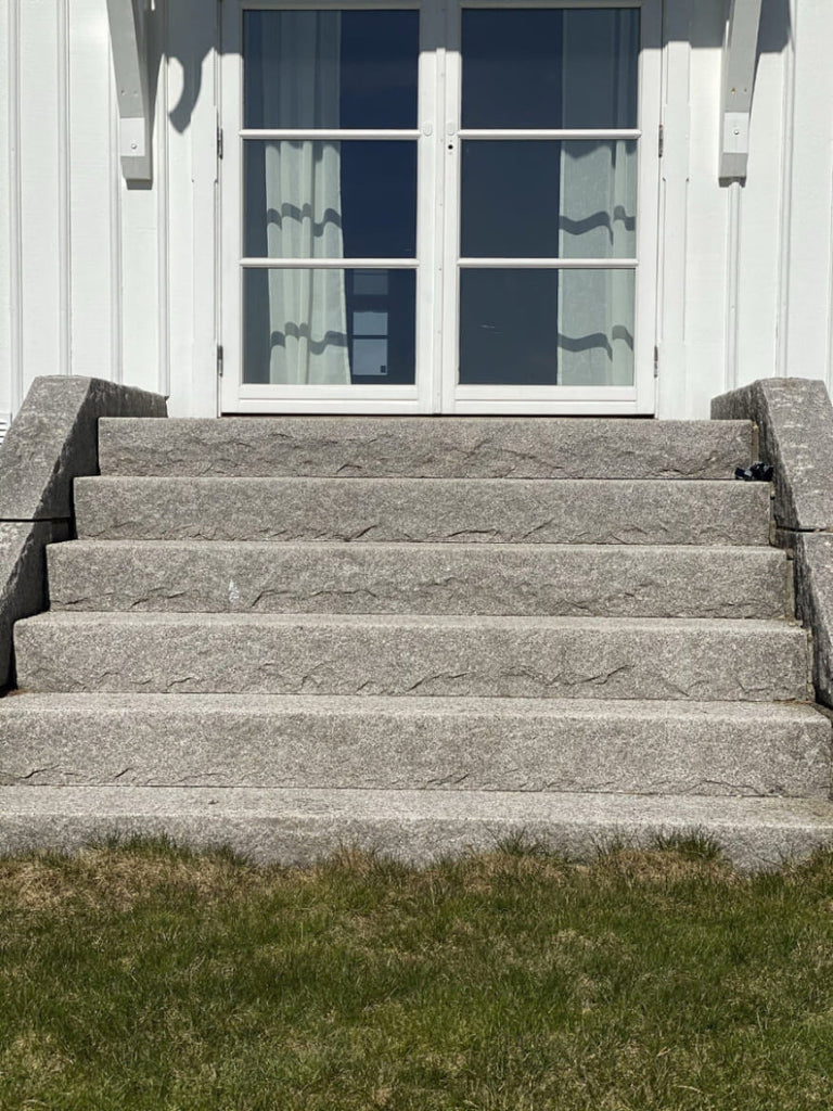 Blocksteg i Bohuslänsgranit med rustik råkilad framkant och flammad toppyta. Passar utmärkt för utomhustrappor. Stengrossen säljer produkten.