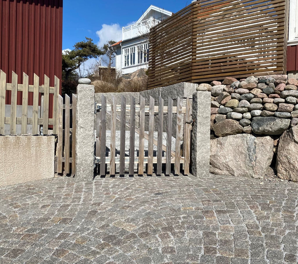 Två granitstolpar i Grå Bohus med råkilad yta, perfekta för infart eller avgränsning. Stengrossen säljer produkten.