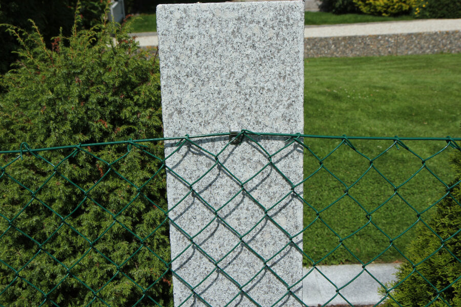 Flammad granitstolpe i närbild med tydlig yta och naturlig färgskiftning. Stengrossen säljer produkten.