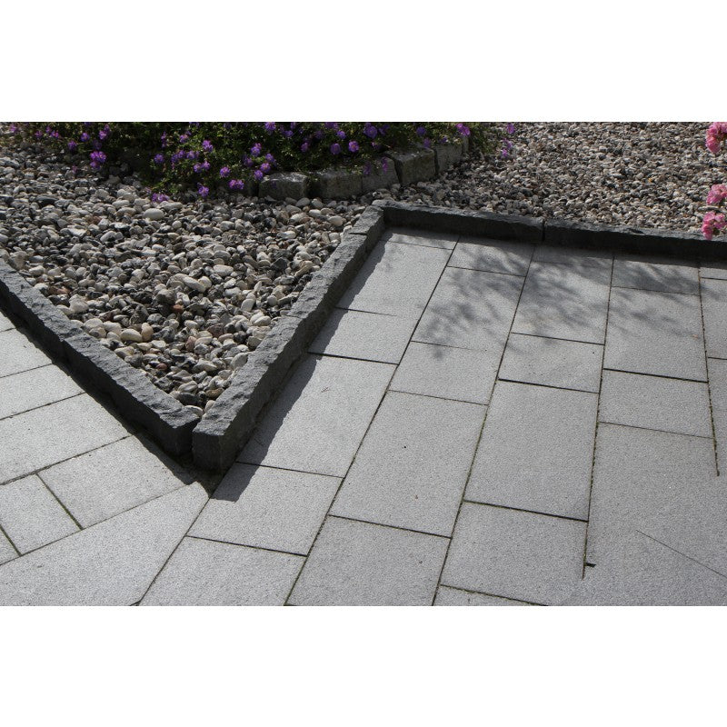 Granitplattor (granithällar) i granit. Färgen är grafitgrå. Plattorna, som också kallas för hällar, är i 2 olika storlekar, 60x30x3 cm och 30x30x3 cm. Runt hällarna är det kantsten i samma kulör. På utsidan av kantstenen är det svartvit sjösten. Säljs av Stengrossen.se