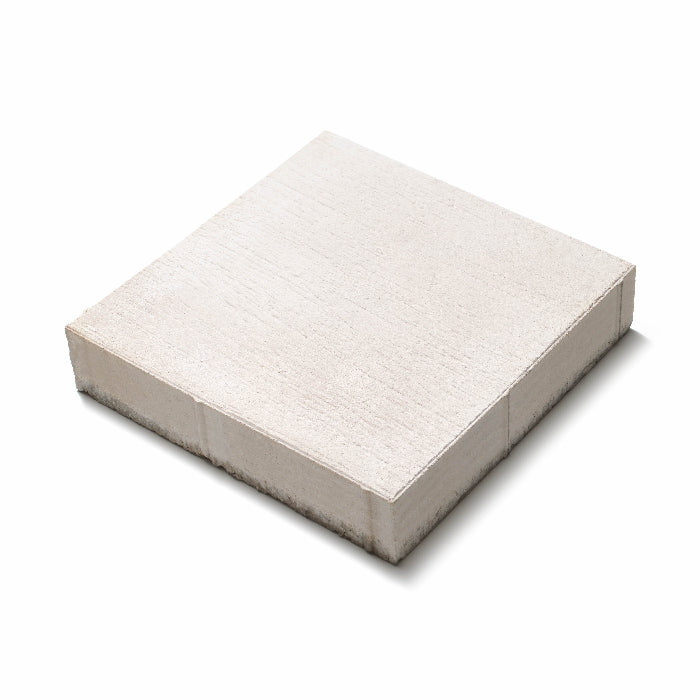 Närbild av vit Ravel-platta med blästrad och lättborstad yta, skapar ett elegant uttryck i offentliga utemiljöer. Storleken är 400x400x80. Stengrossen säljer produkten.