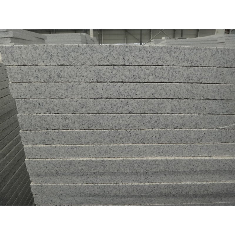 Flera granitplattor som ligger i en hög. Lastade ovanpå varandra. Stensort en är G603. Färgen är grå och dom säljs av Stengrossen.