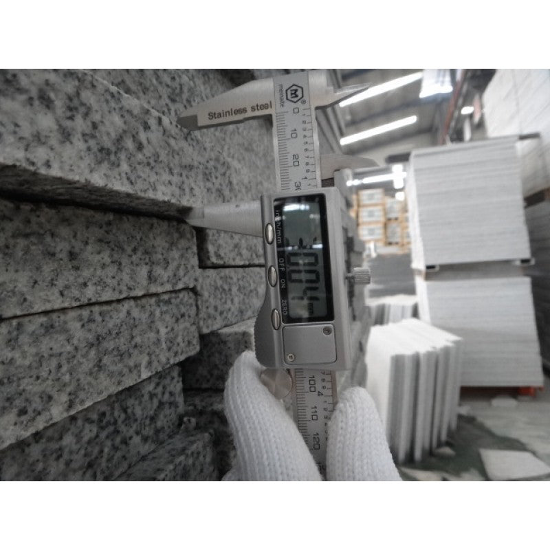 Instrument som mäter tjockleken på våra granitplattor. Bilden visar att tjockleken är 30,04 mm. Färgen är grå. Säljs av Stengrossen.