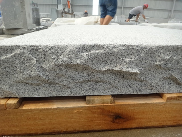 Stilrent och hållbart entréplan i granit med flammad ovansida och råkilad framsida. Stengrossen säljer produkten.