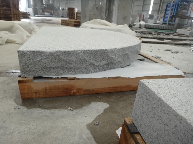 Massivt entréplan i granit med mjuk halvmåneform för ett harmoniskt och gediget intryck. Stengrossen säljer produkten.