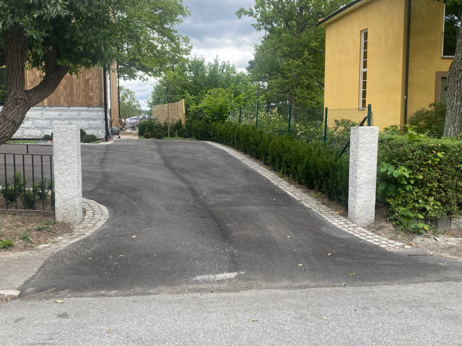 Granitstolpar på varsin sida av en infart för ett stilrent intryck. Stengrossen säljer produkten.