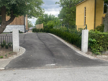 Granitstolpar på varsin sida av en infart för ett stilrent intryck. Stengrossen säljer produkten.