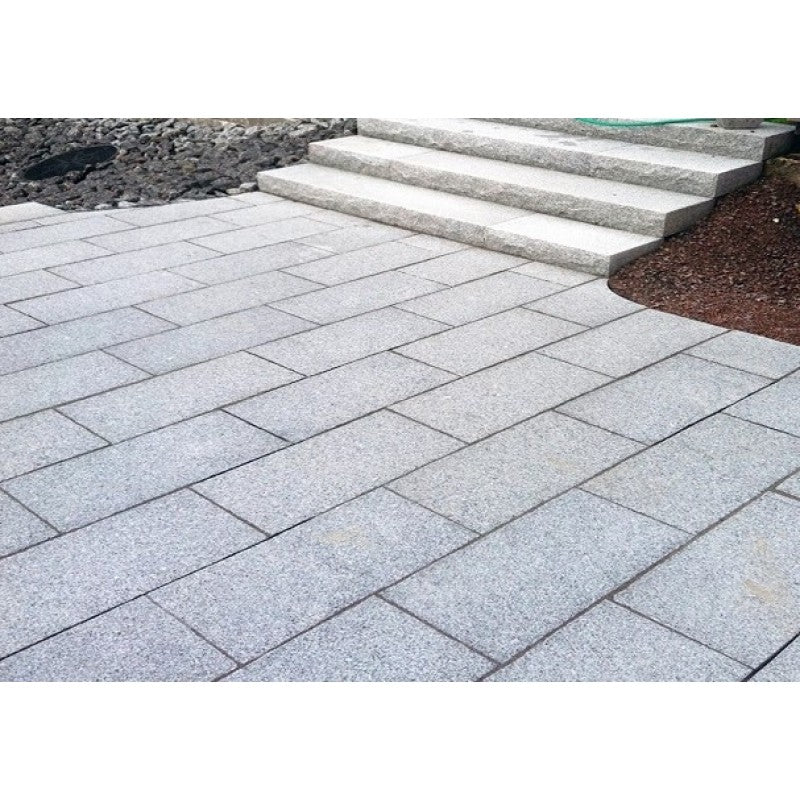 Grå granitplattor framför en trappa som också är i grå granit. Plattorna är i storleken 60x30x3 cm. Säljs av Stengrossen.se