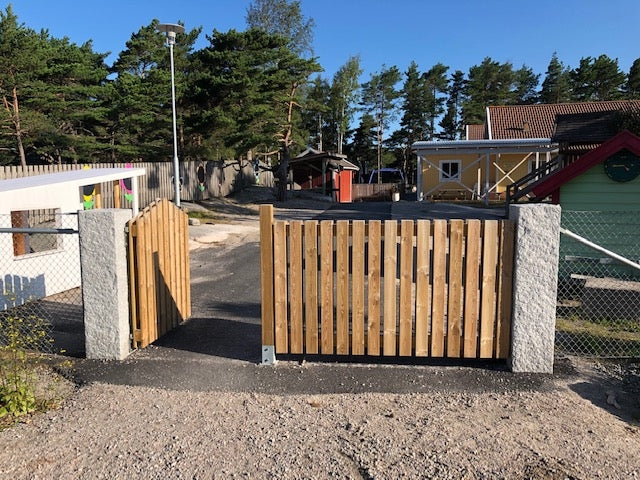 Infart med två grå granitstolpar, perfekt för grind eller belysning. Stengrossen säljer produkten.