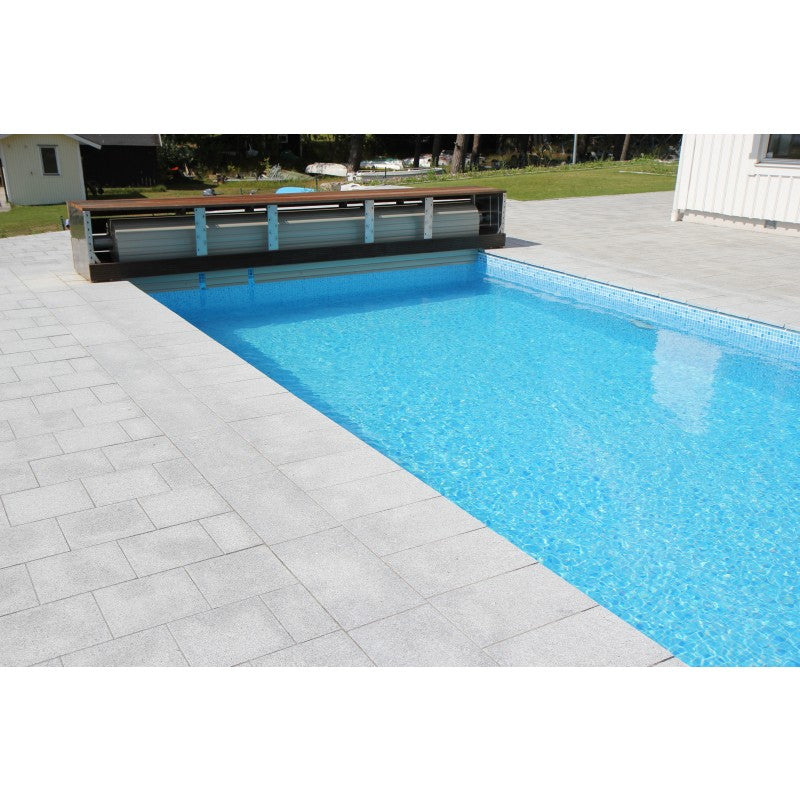 Plattor av sten. Granit. Grå. Ligger runt en pool. Stensort G603. Säljs av Stengrossen.se