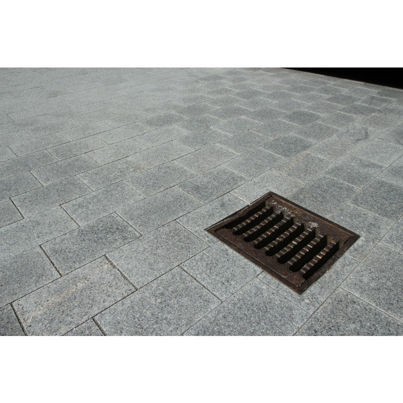 Grå granitplattor runt ett brunnslock. Storleken på plattan är 30x20x6 cm. Denna granitplatta är så tjock så man kan köra med bil på den. Stensorten heter G603. Säljs av Stengrossen.se