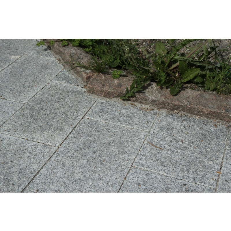 Grå, körbar platta i granit. Inramad med en kantsten i röd granit. Plattornas storlek är 30x20x6 cm. Stensorten heter G603. Säljs av Stengrossen.se