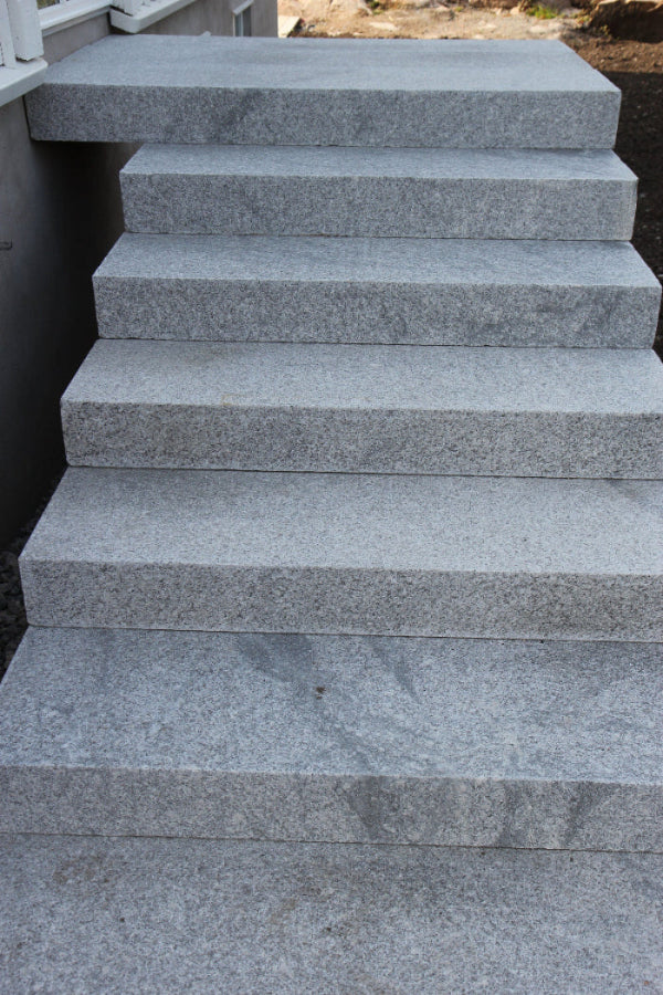 Granitblocksteg för utomhustrappor – Tidlös och hållbar sten med halksäker yta, idealisk för nivåanpassning. Stengrossen säljer produkten.
